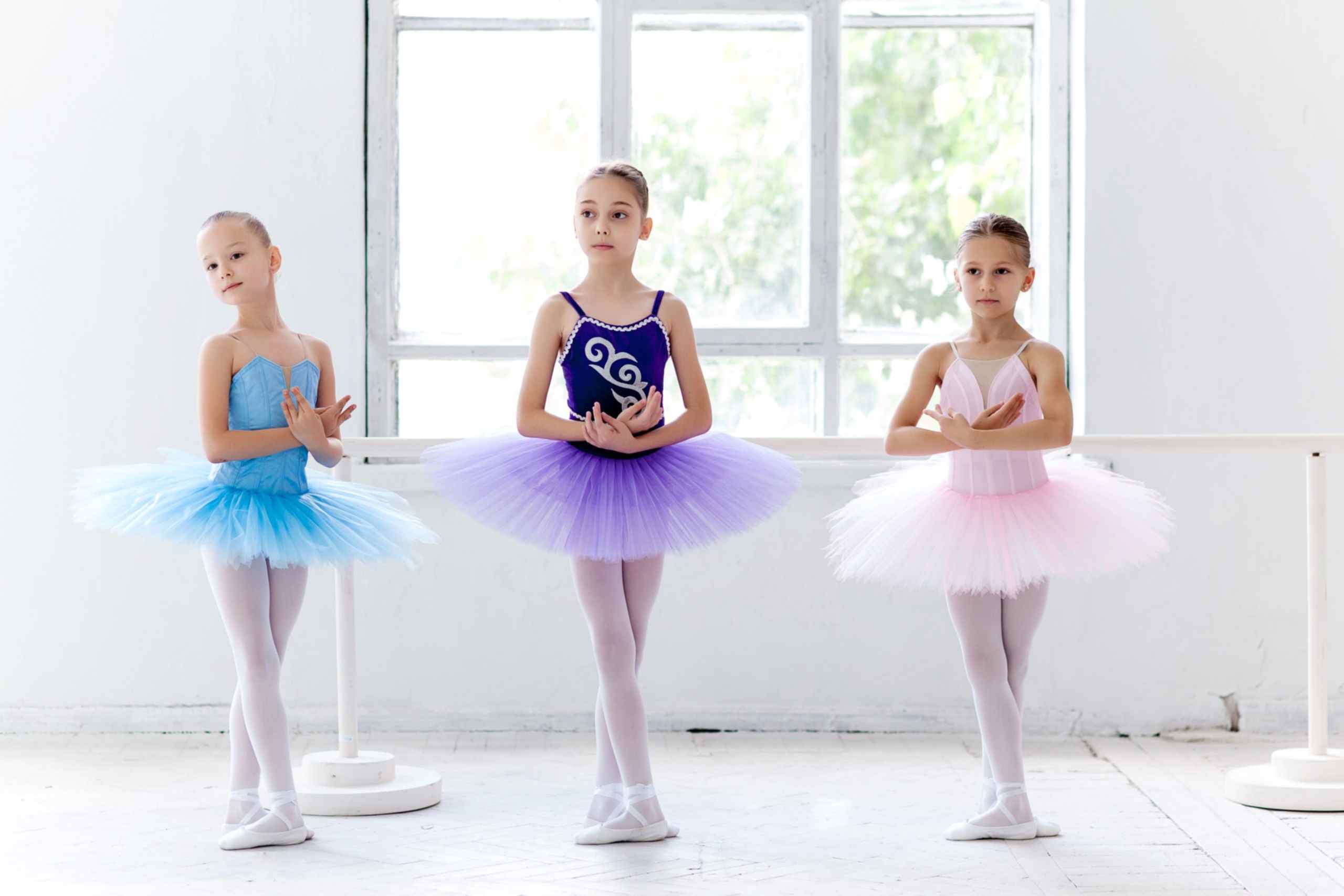 Three little ballet girls in tutu and posing together